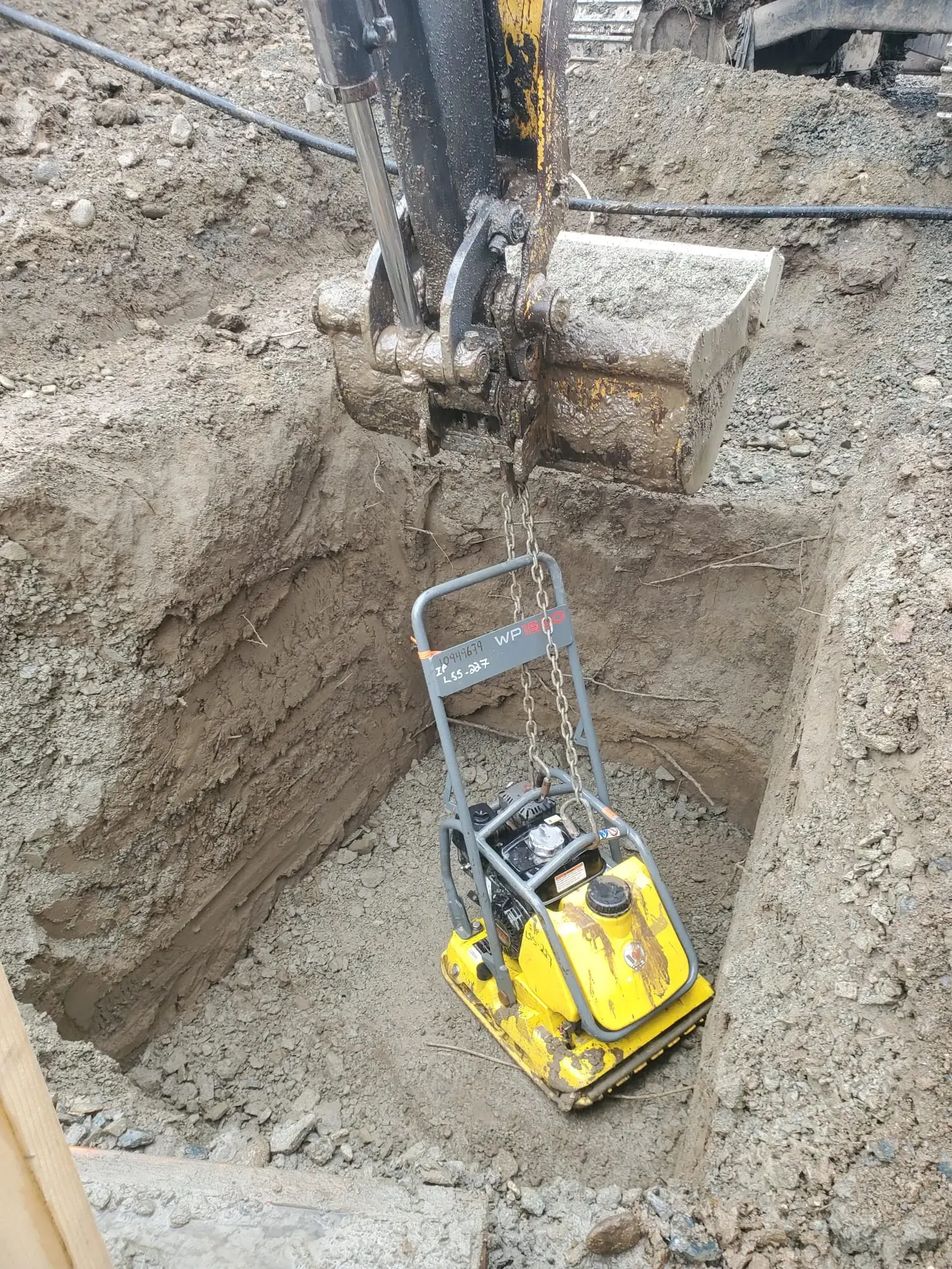 A plate compactor working in a trench