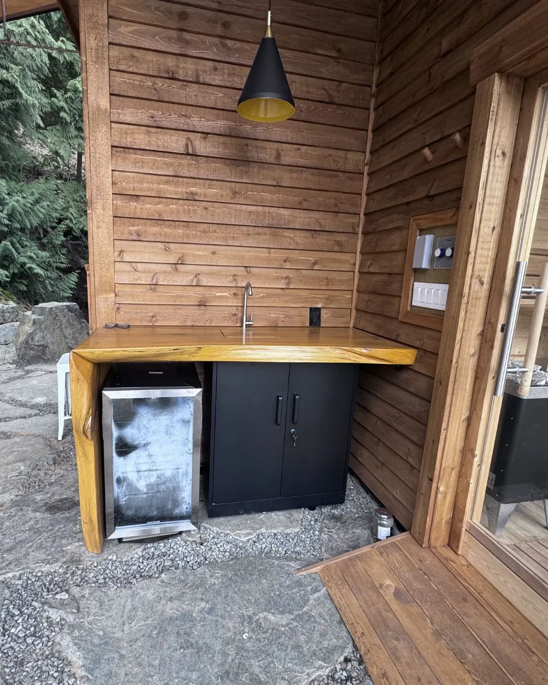 A covered outdoor kitchen counter built in cedar