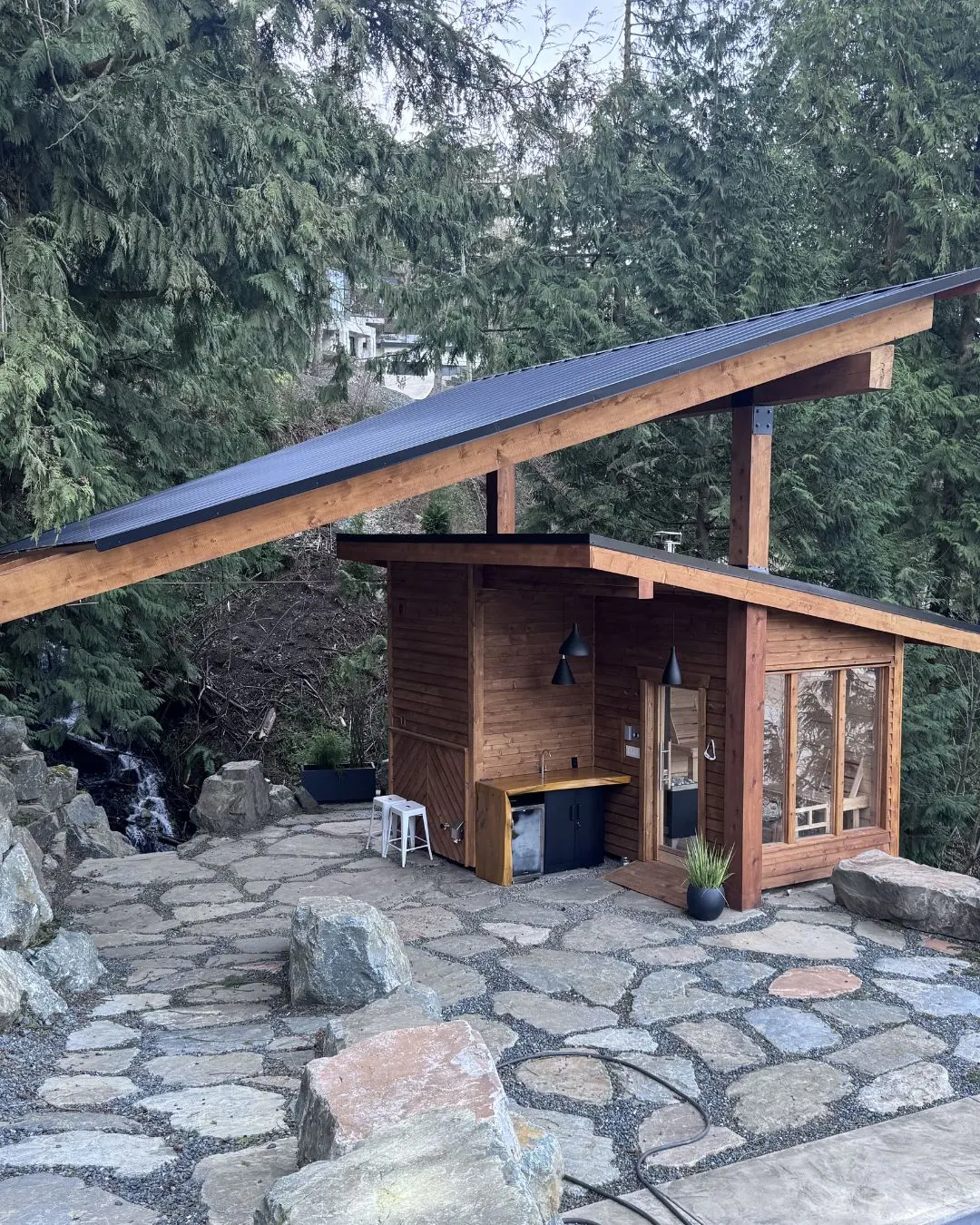 A cedar pavilion on a stone patio