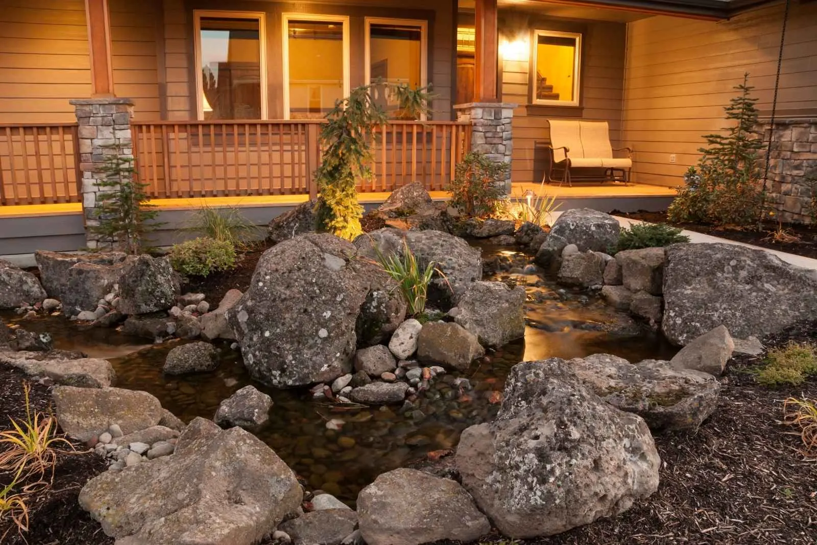 A lit rock water feature at night