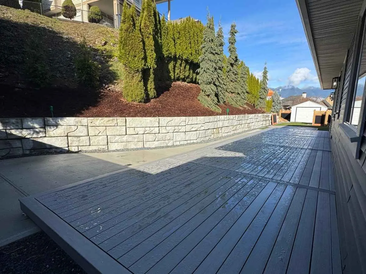 A block retaining wall beside a composite deck
