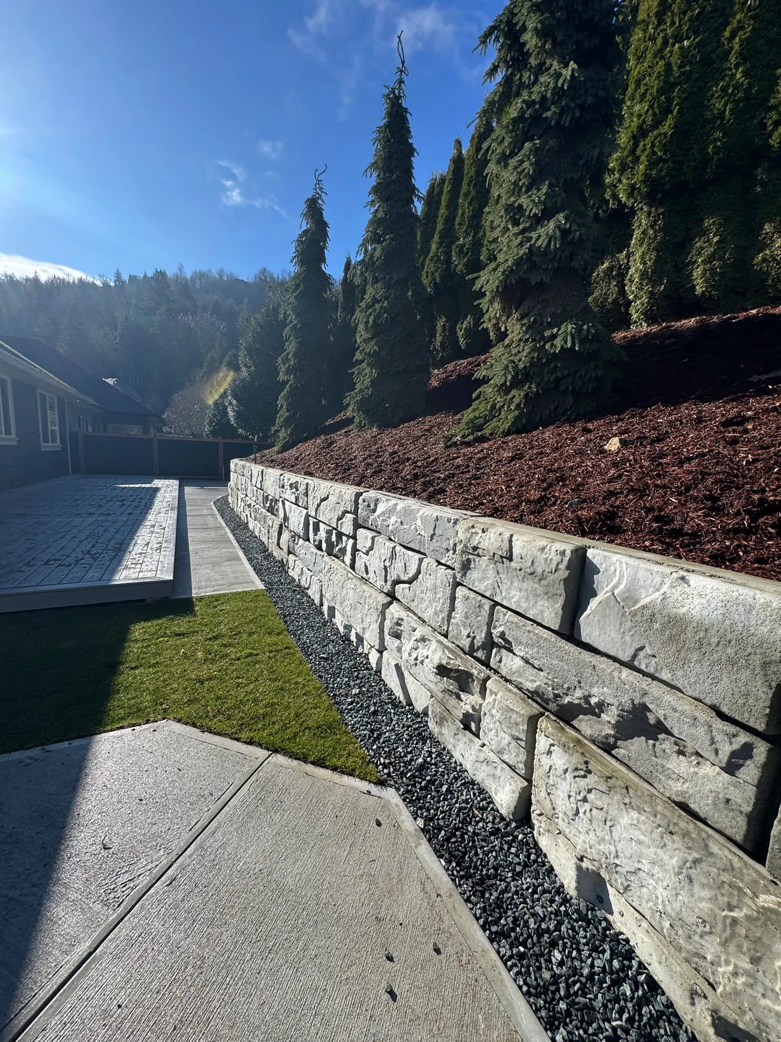 A low block retaining wall running along a lawn