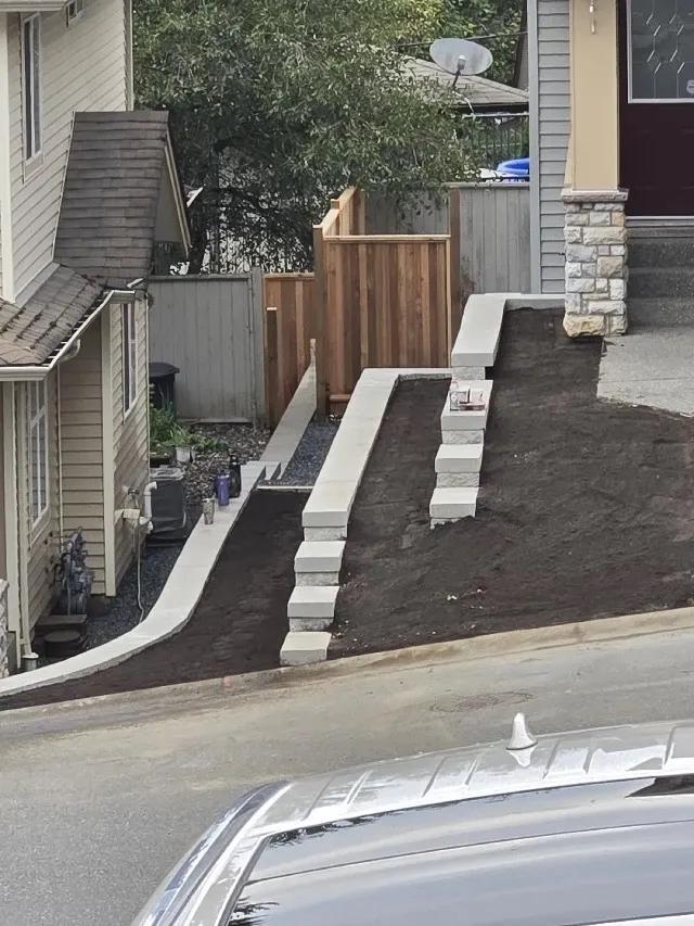 Concrete steps running down beside a driveway