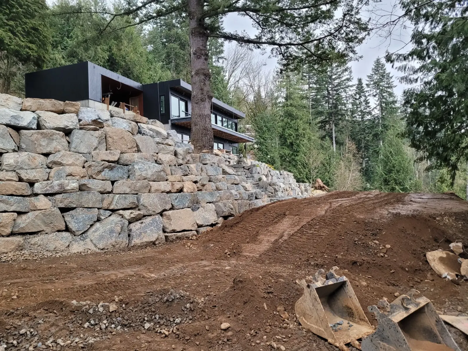 A rock retaining wall part way through being rebuilt