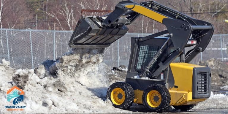 FVC employee moving snow in company skid steer on a client's commercial property downtown Chilliwack, BC.